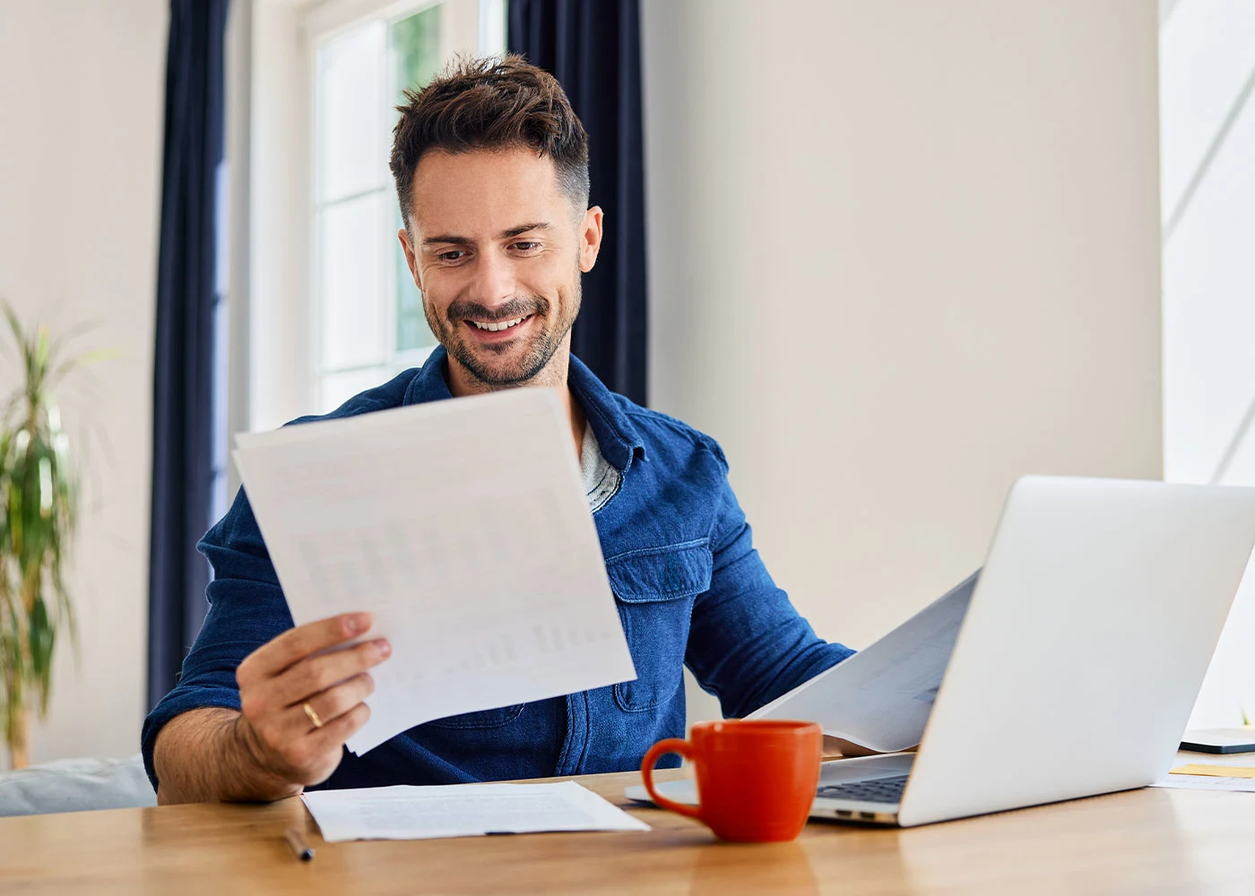 Mann am Tisch mit roter Tasse