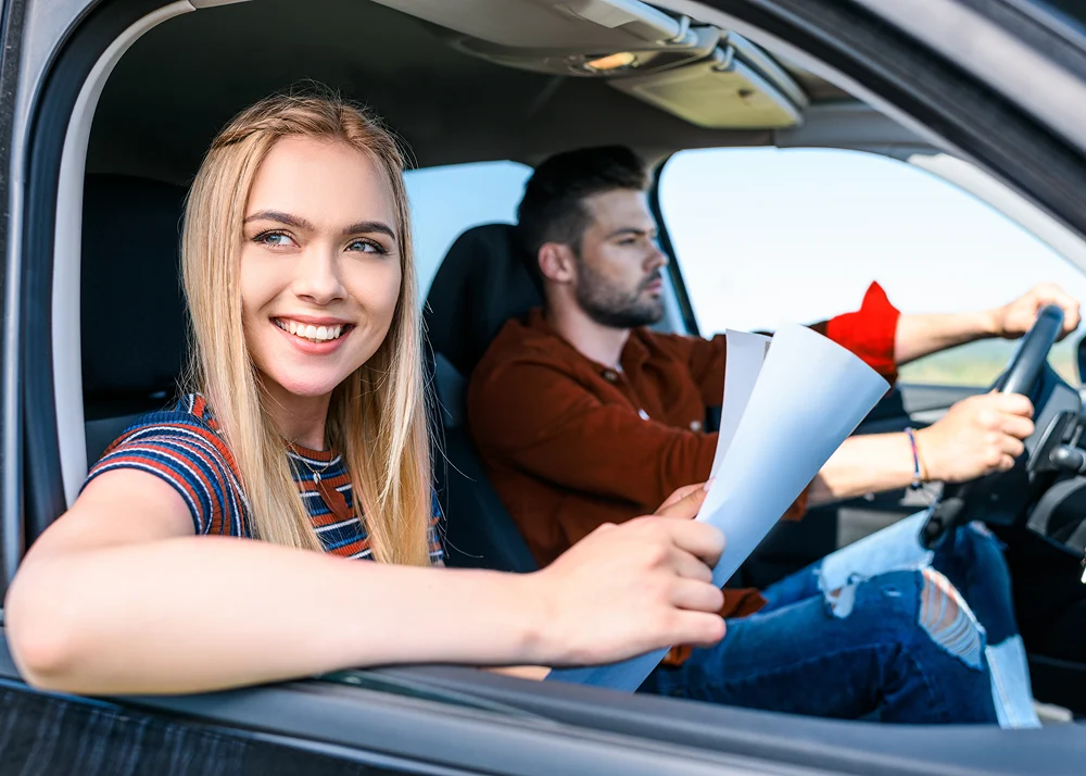 Frau und Mann mit Dokument im Auto
